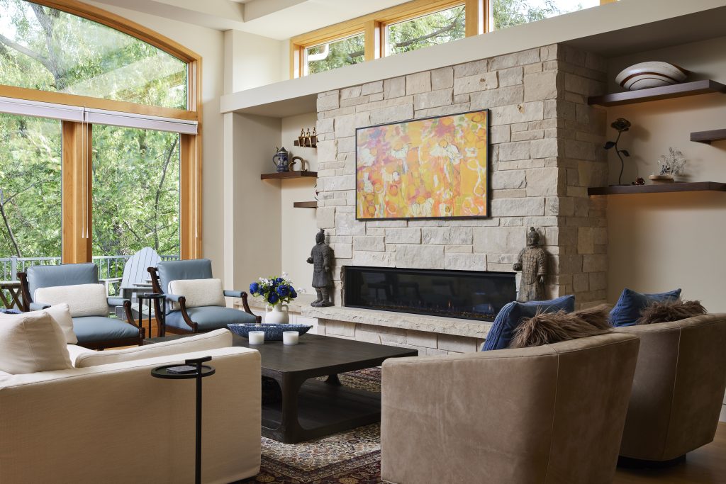 Fireplace feature wall remodel in Edina, Minnesota featuring tape lighting, a linear gas fireplace, custom ledge stone blend, integrated limestone ledge and storage drawers.